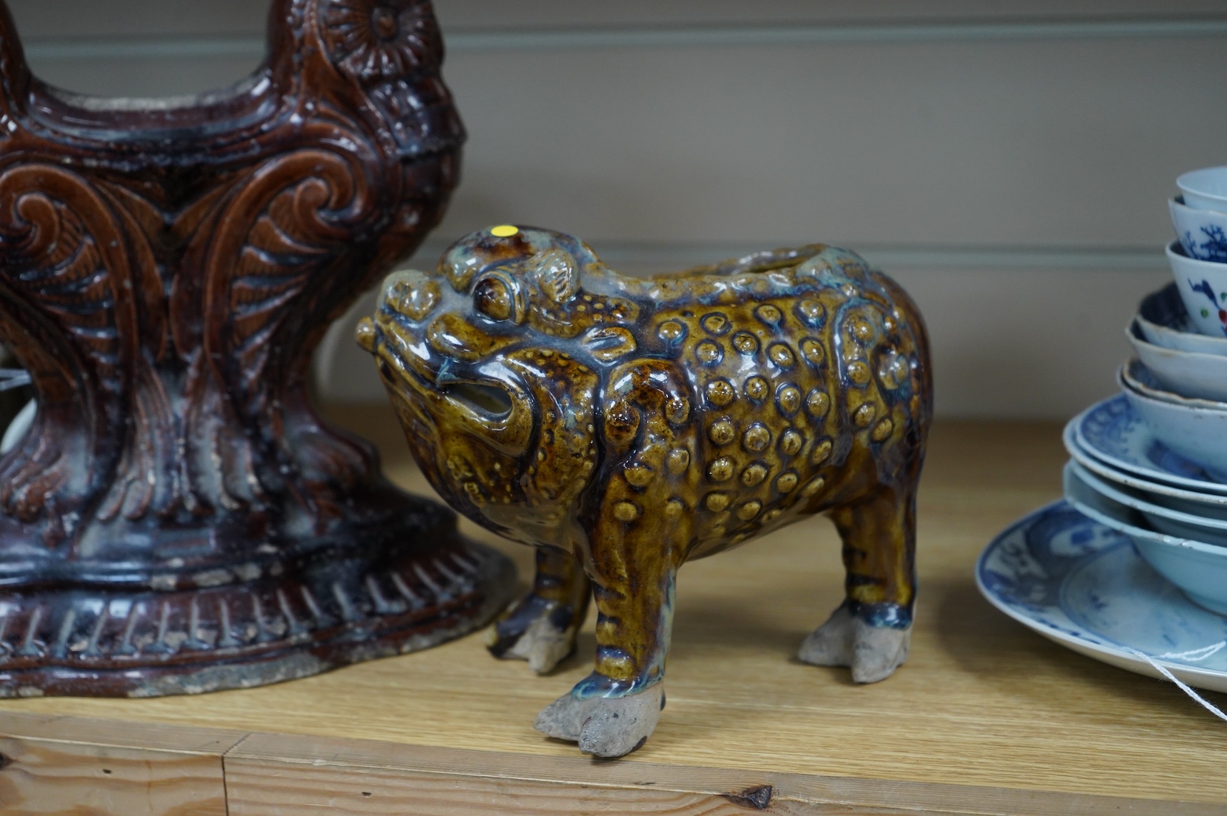 A late 19th century glazed pottery grotesque three legged toad spoon warmer in the manner of Dunmore or Burmantofts, and a Doulton owl andiron, largest 24cm high